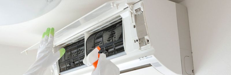 HVAC technician repairing an air conditioner unit in La Mesa CA